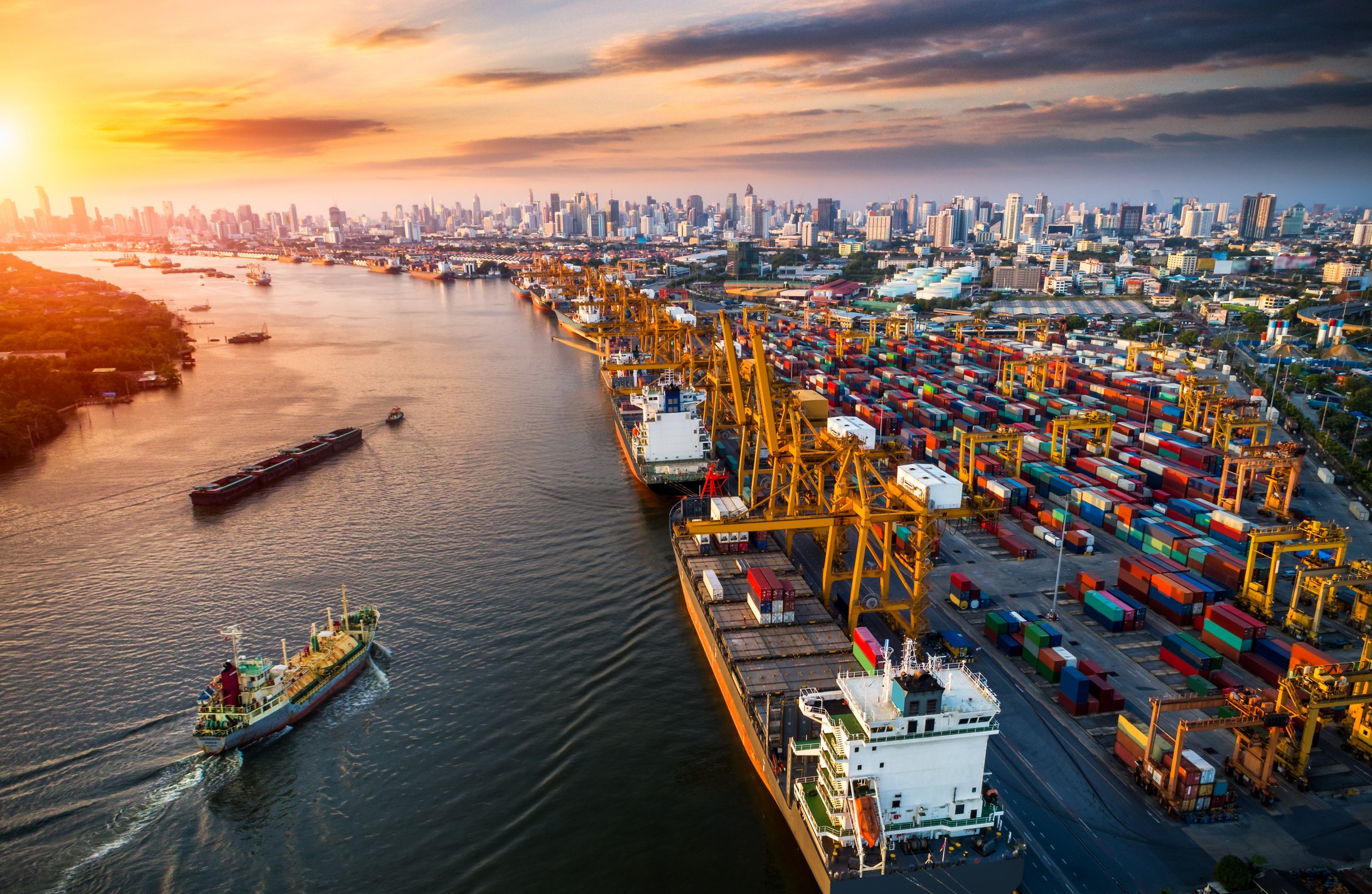 Logistics and transportation of Container Cargo ship and Cargo plane with working crane bridge in shipyard at sunrise, logistic import export and transport industry background